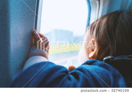 Toddler boy looking out a plane window Toddler boy looking out a plane window 38740199