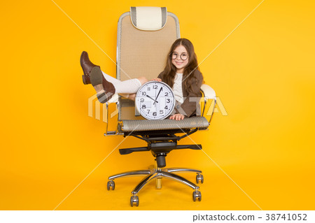 Little brunette girl with clocks in chair Little brunette girl with clocks in chair 38741052