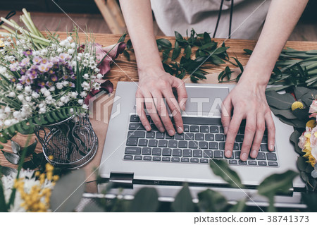 Crop florist using laptop at workplace Crop florist using laptop at workplace 38741373
