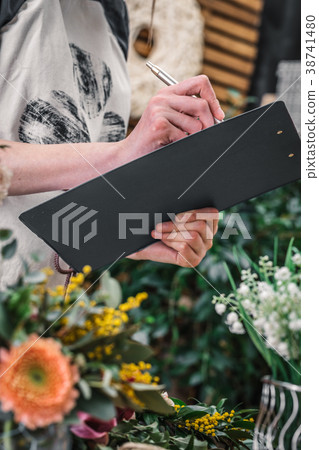 Florist taking notes working in shop 38741480