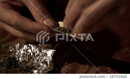 Male hands making joint, rolling marijuana into 38741660