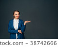 business woman pointing copy space and smiling 38742666
