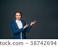 business woman pointing copy space and smiling 38742694
