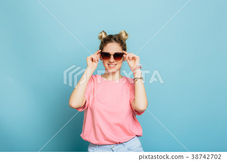 woman dressed in sunglasses on a blue background 38742702
