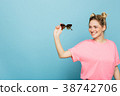 woman holding sunglasses on a blue background 38742706