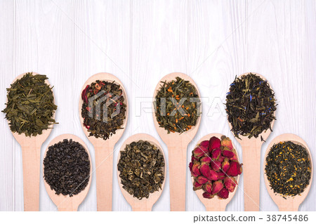Set of different dry herbal teas in wooden spoons on a white wooden background Set of different dry herbal teas in wooden spoons on a white wooden background 38745486