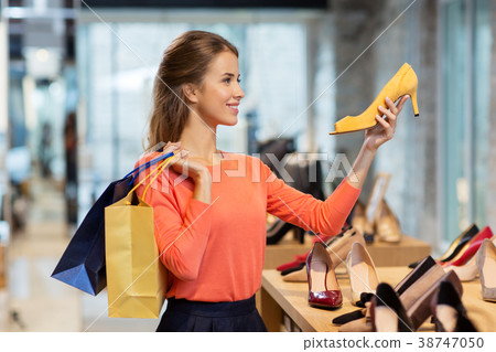 happy young woman choosing shoes at store happy young woman choosing shoes at store 38747050