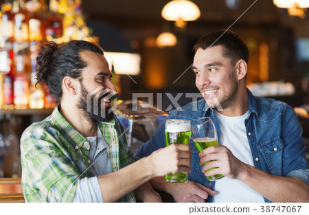 male friends drinking green beer at bar or pub 38747067