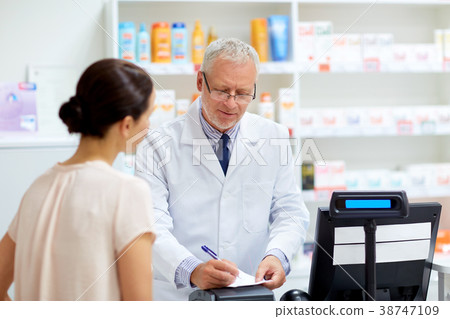 senior apothecary with prescription at pharmacy 38747109