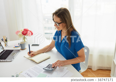 woman with calculator and notebook at office 38747171