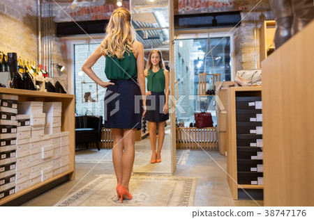 young woman in high-heeled shoes at store mirror young woman in high-heeled shoes at store mirror 38747176