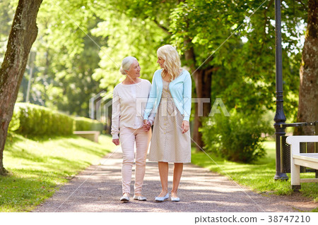 daughter with senior mother walking at summer park daughter with senior mother walking at summer park 38747210