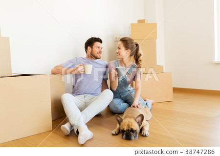 happy couple with boxes and dog moving to new home 38747286