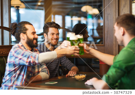 male friends drinking green beer at bar or pub male friends drinking green beer at bar or pub 38747329