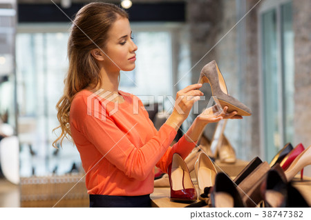 young woman choosing shoes at store young woman choosing shoes at store 38747382