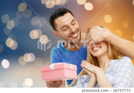 happy couple with present over lights background happy couple with present over lights background 38747772