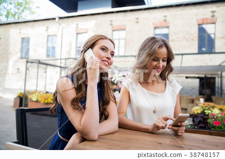 young women with smartphones and coffee at cafe young women with smartphones and coffee at cafe 38748157
