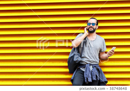 man with earphones and smartphone over wall man with earphones and smartphone over wall 38748648