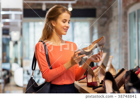 happy young woman choosing shoes at store 38748841