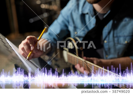 musician with guitar and music book at studio 38749020