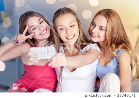 teen girls with smartphone taking selfie at home teen girls with smartphone taking selfie at home 38749171