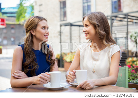 happy young women drinking coffee at outdoor cafe happy young women drinking coffee at outdoor cafe 38749195