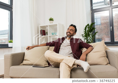 man in earphones with tablet pc listening to music man in earphones with tablet pc listening to music 38749225