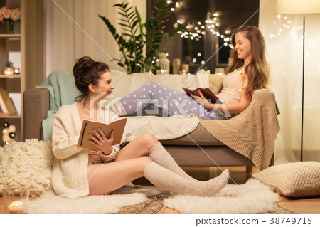 female friends with book and sketchbook at home 38749715