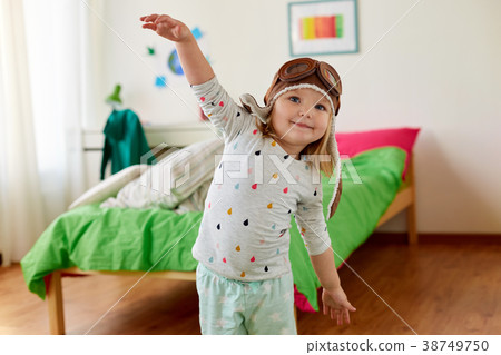happy little girl in pilot hat playing at home 38749750