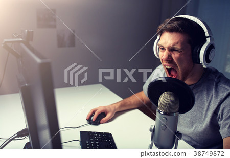 man in headset playing computer video game at home man in headset playing computer video game at home 38749872
