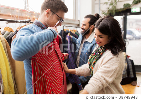 friends choosing clothes at vintage clothing store 38749948