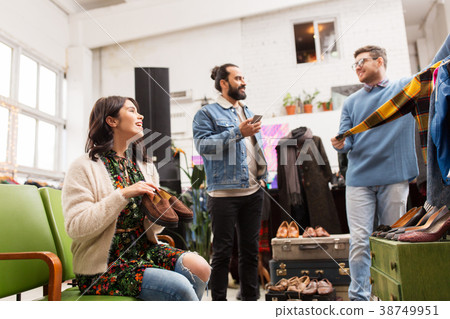 friends choosing clothes at vintage clothing store 38749951