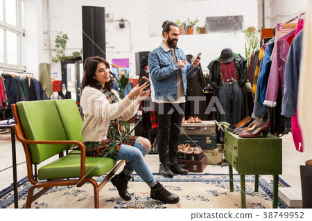 couple choosing footwear at vintage clothing store couple choosing footwear at vintage clothing store 38749952