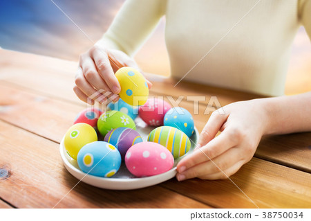close up of woman hands with colored easter eggs close up of woman hands with colored easter eggs 38750034