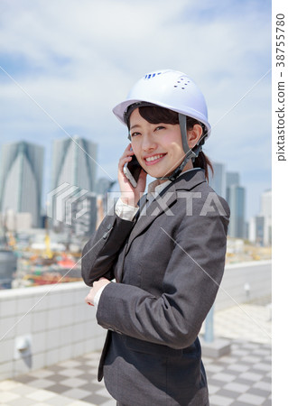 Young woman in suit wearing a helmet on the phone Young woman in suit wearing a helmet on the phone 38755780