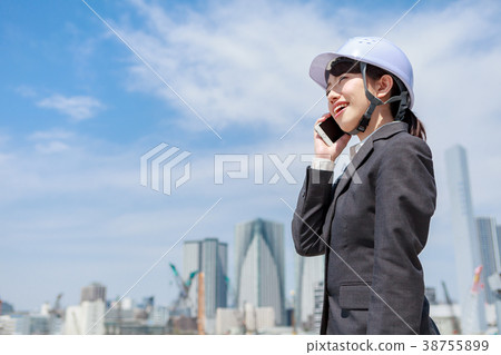 Young woman in suit wearing a helmet on the phone Young woman in suit wearing a helmet on the phone 38755899