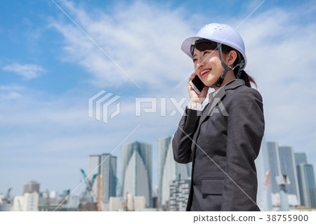 Young woman in suit wearing a helmet on the phone Young woman in suit wearing a helmet on the phone 38755900