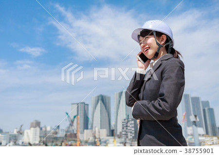 Young woman in suit wearing a helmet on the phone 38755901