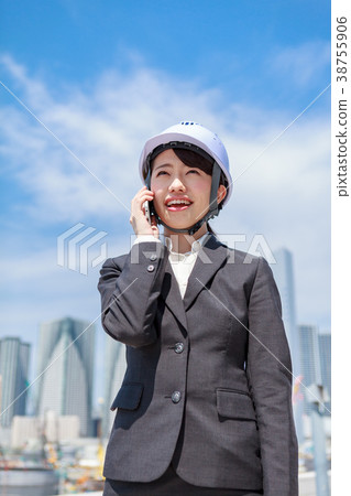 Young woman in suit wearing a helmet on the phone 38755906