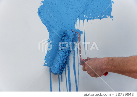 Male hand painting wall in blue with paint roller. 38759048