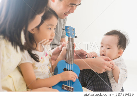 Family playing ukulele at home Family playing ukulele at home 38759439