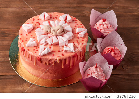 Pink baby shower cake on wooden background 38767236