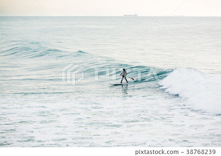 Surfer on sup board on ocean waves. 38768239