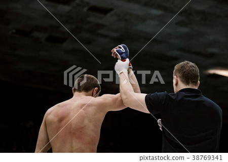 referee lifting hand of victorious fighter referee lifting hand of victorious fighter 38769341