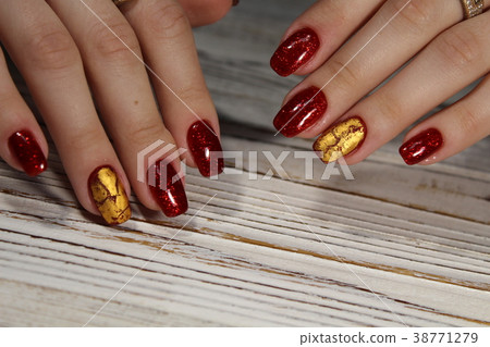 Manicured nails colored with red nail polish 38771279