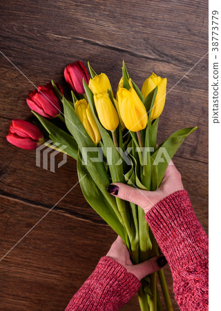 Florist makes a bouquet of yellow and red tulips Florist makes a bouquet of yellow and red tulips 38773779