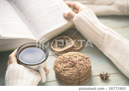 Girl reading book and drinking tea in winter Girl reading book and drinking tea in winter 38773903