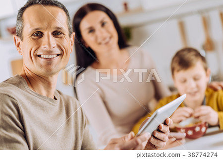 Handsome man posing with tablet during breakfast 38774274