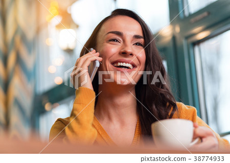 Charming joyful woman having phone conversation Charming joyful woman having phone conversation 38774933