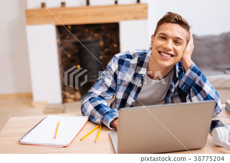 Happy teenager learning his lessons at home Happy teenager learning his lessons at home 38775204